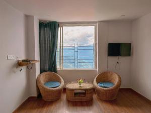 a room with two chairs and a table and a window at HOTEL ARMS near SUMI Boys School in Kalimpong