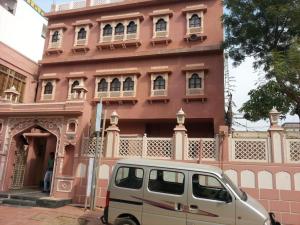 Jhunjhunūn的住宿－Palace Fresco，停在粉红色建筑前面的货车