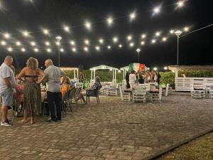 a group of people standing around a patio at night at Hotel La Torretta in Castel San Pietro Terme