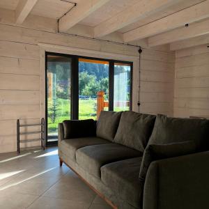 a living room with a couch and a large window at Chalet PidStromom in Mykulychyn