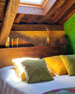 Cama en habitación con techo de madera en Apartamentos Rurales El Bosque de las Viñas, en Boal