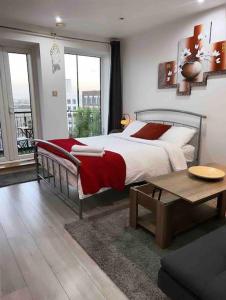 - une chambre avec un grand lit et une table dans l'établissement Entire Flat with balcony, à Londres