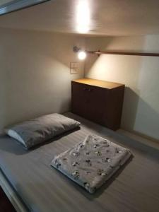 - une petite chambre avec un lit et une commode dans l'établissement Smile Capsule Hostel, à Chiang Mai