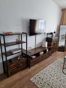 a living room with a television on a wall at La Cetate Luxury Apartment in Ipoteşti