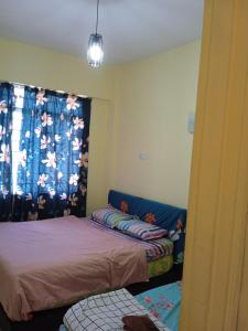 um quarto com 2 camas e uma janela com uma cortina em Cozy Seaview Glory Beach Resort ANC em Porto Dickson