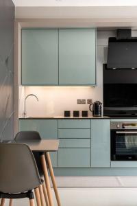 a kitchen with white cabinets and a table and chairs at Summer work base Isle of Grain contractors - Apartment 7 in Gillingham +32 photos
