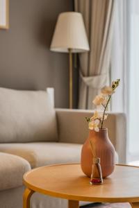 Un jarrón con flores sobre una mesa en una sala de estar. en Business Bay's Coziest Hideaway With Balcony, en Dubái
