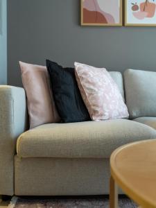 un sofá con 3 almohadas en la sala de estar en Business Bay's Coziest Hideaway With Balcony, en Dubái