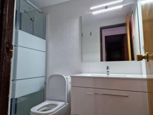a bathroom with a sink and a toilet and a mirror at Camping Los Pinos in Peñíscola