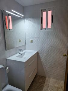 a bathroom with a white sink and a mirror at Camping Los Pinos in Peniscola