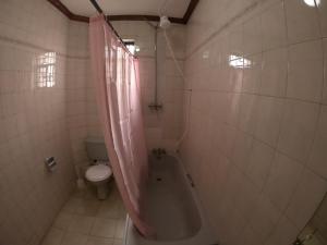 a bathroom with a bath tub and a toilet at Nairobi Backpackers Hostel in Nairobi