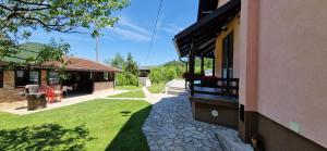 ein Haus mit einem Rasenplatz neben einem Gebäude in der Unterkunft Holiday Home Emir in Račić