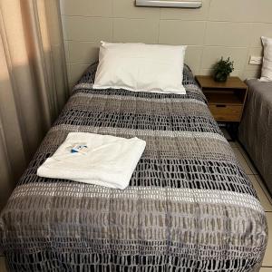 Una cama con una camiseta blanca. en Jambin hotel motel, 