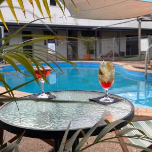 una mesa con una bebida junto a una piscina en Jambin hotel motel, 
