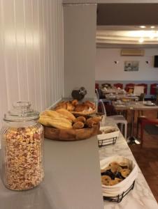a table with a tray of bread and a bowl of nuts at Hôtel Le Cheval Blanc in Saint-Maixent-lʼÉcole
