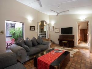 a living room with a couch and a piano at The Art House Victoria Falls in Victoria Falls