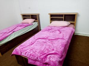 duas camas num quarto com cobertores cor-de-rosa em رأس منيف /عجلون em Ajlun