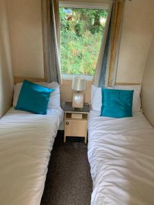 two beds in a small room with a window at Kingsgate 49 in Shanklin