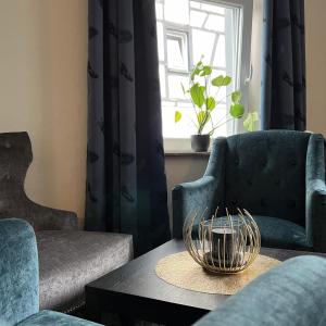 a living room with two chairs and a table and a window at Breitbacher Hof in Waldbreitbach