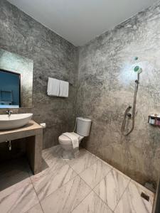 uma casa de banho com um WC, um lavatório e um chuveiro em A Hotel Cozy em Ban Pa Sak