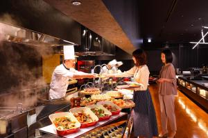 a group of people standing in a kitchen preparing food at TAOYA Nasu Shiobara in Nasushiobara