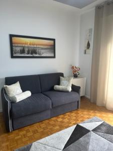 una sala de estar con un sofá azul en una habitación en CEJM Apartments Merano en Merano