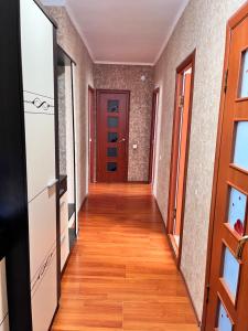 un couloir d'un appartement avec une porte rouge dans l'établissement Апартаменты с 2 спальнями, à Atyraū