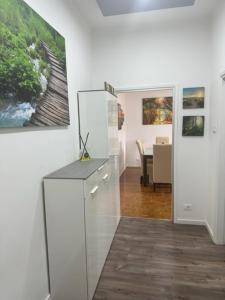 um quarto branco com uma pintura na parede em CEJM Apartments Merano em Merano