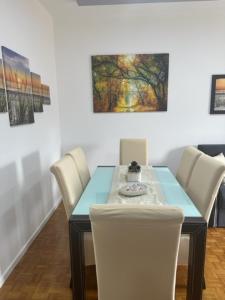 a dining room with a blue table and white chairs at CEJM Apartments Merano in Merano