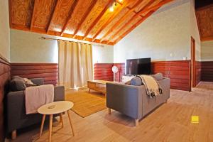 een woonkamer met 2 banken en een televisie bij Coastal Dayz in Jurien Bay