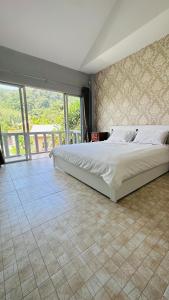 1 dormitorio con cama grande y ventana grande en Peaceful Retreat Villa by Nai Thon beach en Phuket
