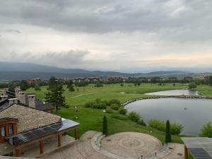 uitzicht op een golfbaan en een meer bij Private Apartment Pirin Golf Club with Lake View in Razlog