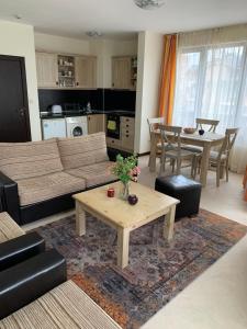 sala de estar con sofá y mesa en Private Apartment Pirin Golf Club with Lake View, en Razlog