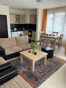 a living room with a couch and a table at Private Apartment Pirin Golf Club with Lake View in Razlog