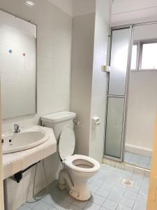 uma casa de banho com um WC, um lavatório e um chuveiro em 4BR 9pax in Kuching city em Kuching