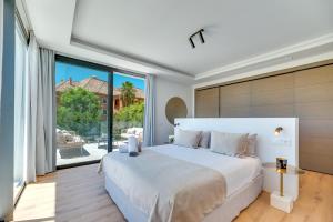 een slaapkamer met een groot wit bed en een groot raam bij VACATION MARBELLA I Villa Monte Halcones, Private-Pool, Brand-New, Incredible Views, Near Golf Valley in Benahavís