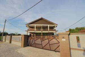 une maison avec un portail et une clôture dans l'établissement Villa De Lova - Wakaf Che Yeh, à Kota Bharu