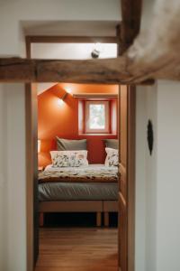 オービニー・シュル・ネールにあるLe Lys Écossaisのオレンジ色の壁のドミトリールームのベッド1台分です。