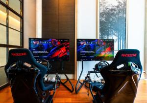 two chairs in a room with two monitors and aereoereo at Grande Centre Point Hotel Terminal21 in Bangkok