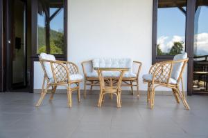 a wooden table and four chairs sitting on a porch at Rusaliite Adventure House in Bachevo