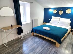 a bedroom with a bed with a blue wall at Au Bon Endroit in Aiguilhe