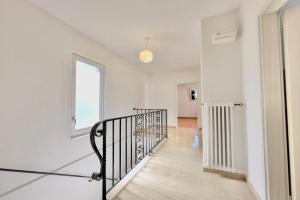 pasillo con paredes blancas y escalera con ventana en Casa Carolina 1 and Casa Carolina 2 - Happy Rentals, en Losone