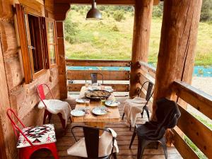 eine Veranda mit einem Tisch und Stühlen in einer Hütte in der Unterkunft Wilk u Drzwi in Ustrzyki Dolne