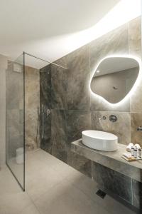 a bathroom with a glass shower and a sink at OPSIS Suites in Limenaria +35 photos