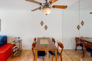 a dining room with a table and chairs and a couch at Kitschy Rich Palm Springs Permit #60096 in Palm Springs