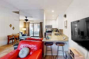 a living room with a red couch and a kitchen at Kitschy Rich Palm Springs Permit #60096 in Palm Springs