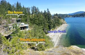 a house on the shore of a body of water at Waterfront Room2 with Private Bath near Marina in Gibsons