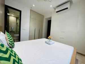 a bedroom with a large white bed with a air conditioner at 1BR Mumbai theme Apartment In Powai by Florastays in Mumbai