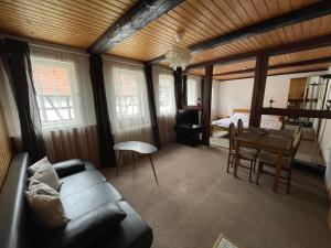 uma sala de estar com um sofá, uma mesa e uma cama em "Altes Haus" am Kurpark in den Bergen em Zorge