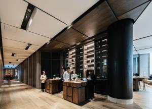 a lobby of a building with people standing around a counter at CHAO Sanlitun Beijing in Beijing